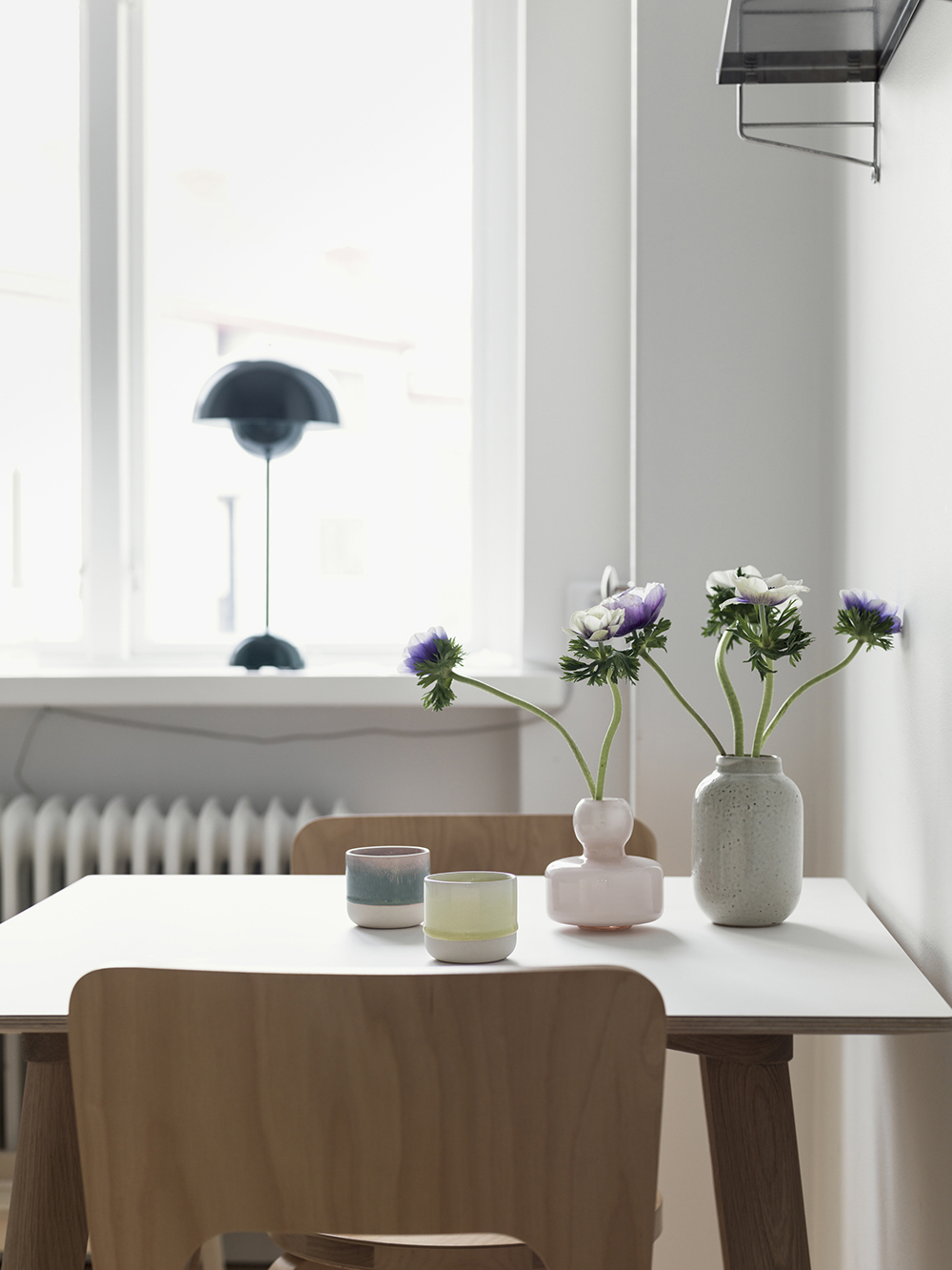 Matplats med ett litet bord och två stolar i närbild med vaser och blommor som dekoration. 